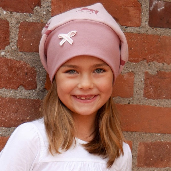 Mädchen trägt rosa Einhorn Wintermütze | by Anton & Sophie